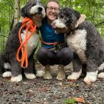 Woman crouching with two dogs