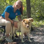 Woman kneeling with a dog