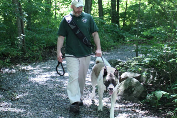 Man taking a dog on a nature walk